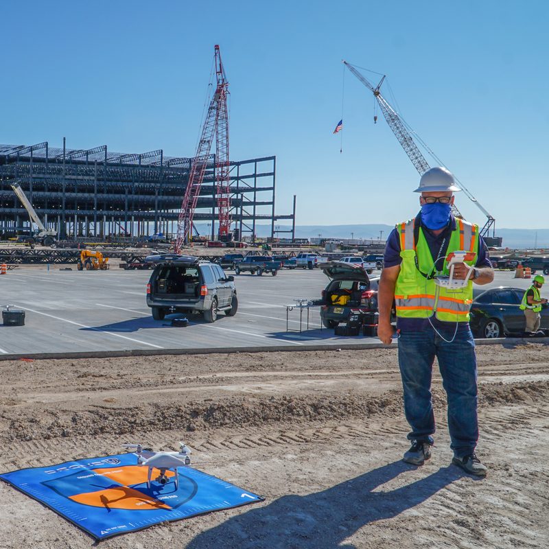 Amazon drone pilot jobs - Drone U pilot in a hard hat launching a drone from a landing pad on a job site