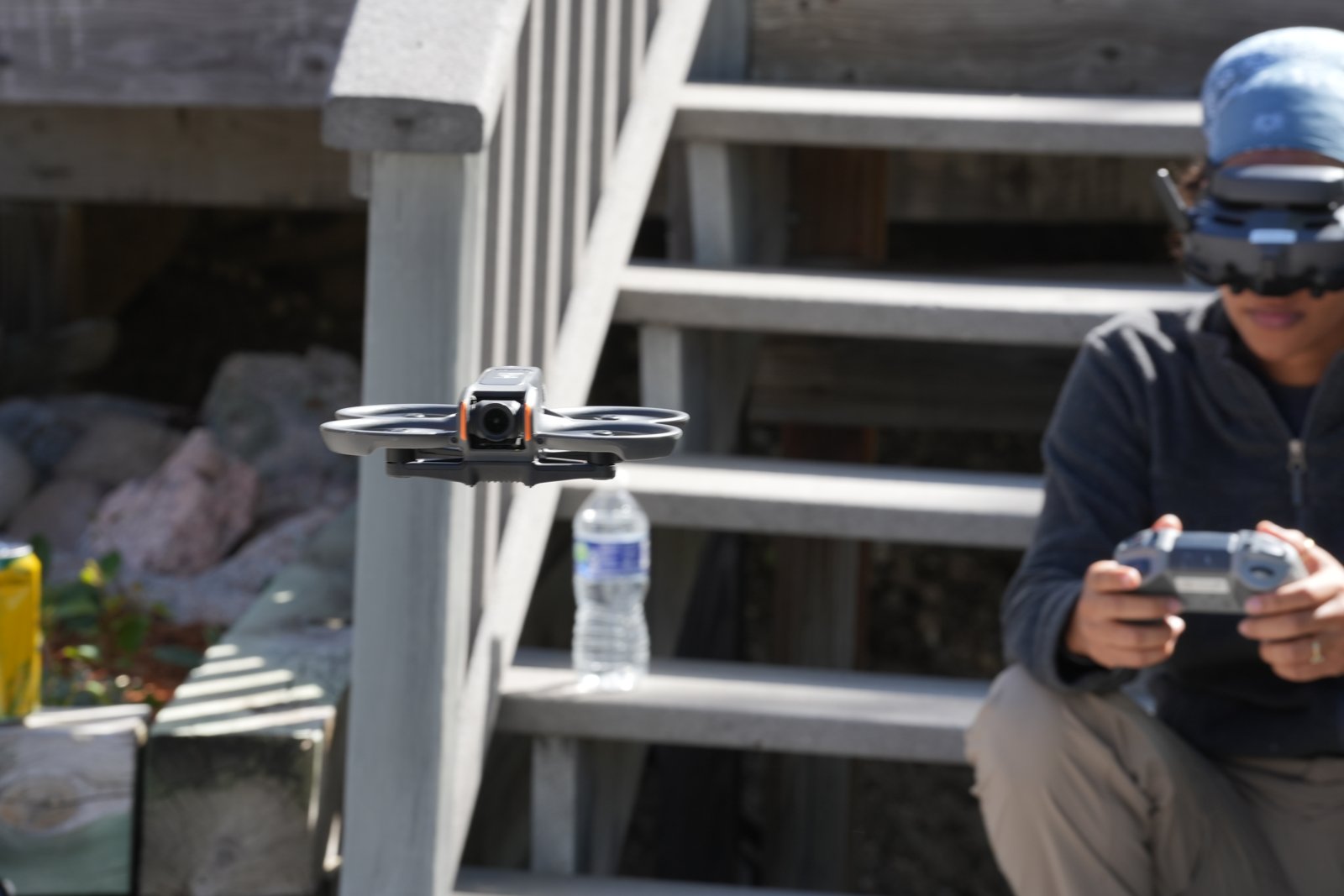 Pilot holding a DJI RC Motion 3 controller while a DJI Avata 2 hovers in front of them