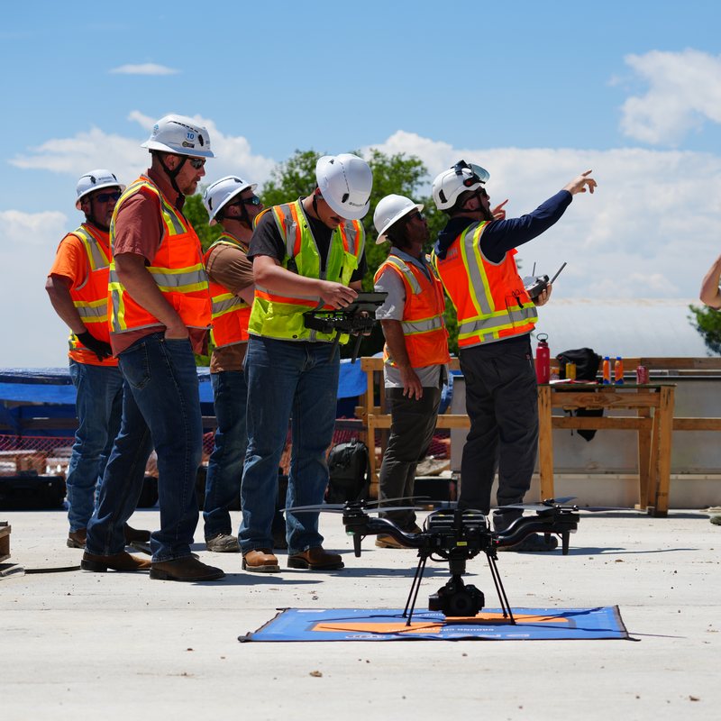 Enterprise team in hard hats training on a drone ahead of the Part 107 test changes